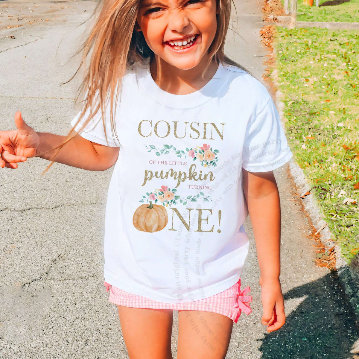 Laughing girl outdoors in a white Cousin of the Little Pumpkin kids tee.