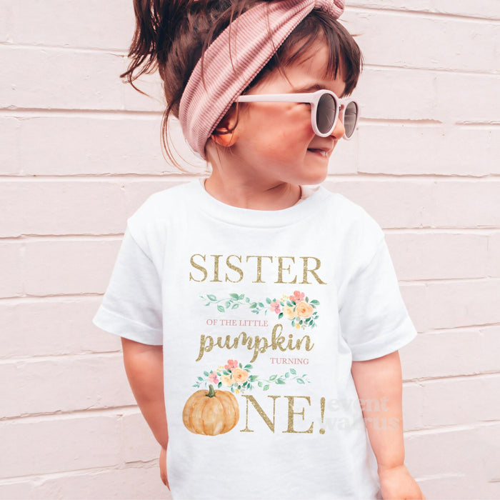 Girl in sunglasses and a pink headband wearing a white Sister of the Little Pumpkin shirt.
