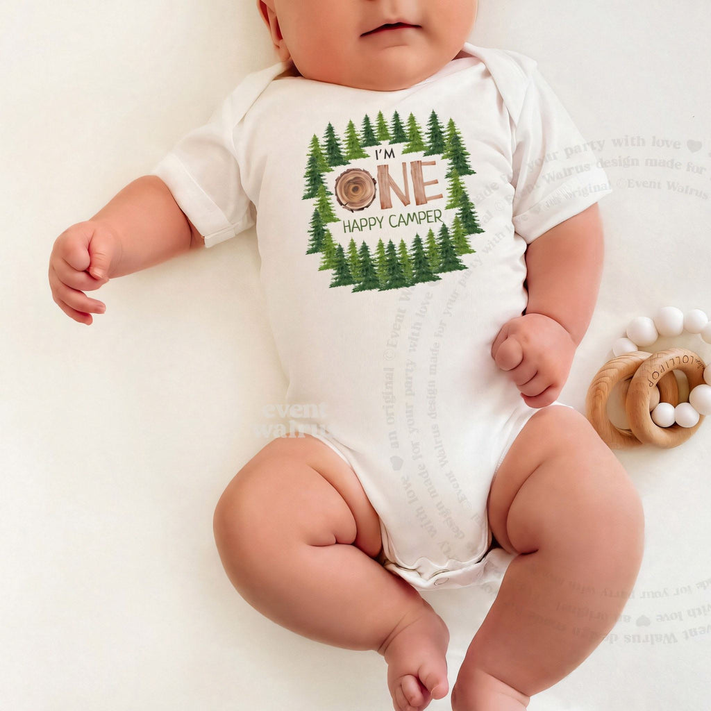 Baby lying on a white blanket in a white One Happy Camper bodysuit.