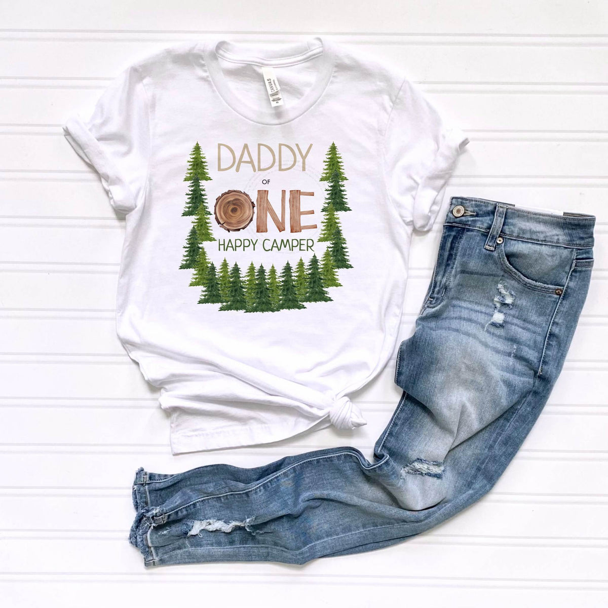 White Daddy One Happy Camper tee laid flat beside jeans.