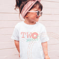Girl in sunglasses and a pink headband wearing a white Two Sweet donut shirt.