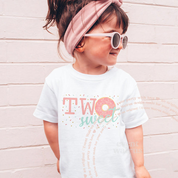 Girl in sunglasses and a pink headband wearing a white Two Sweet donut shirt.
