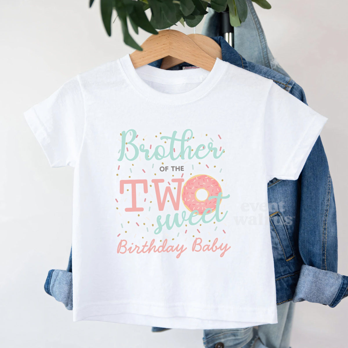 White Brother of the Two Sweet toddler tee on a hanger over a denim jacket.
