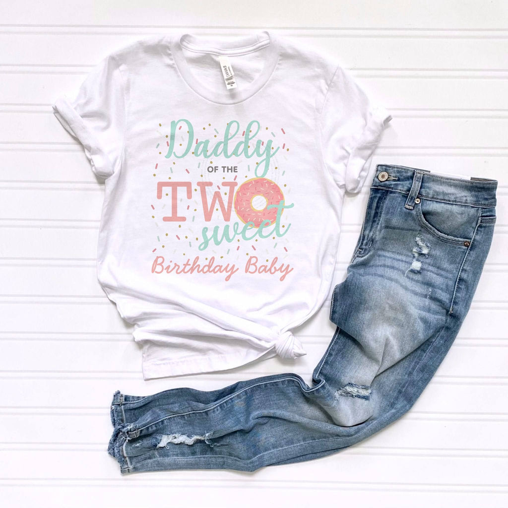 White Daddy of the Two Sweet tee laid flat beside jeans.