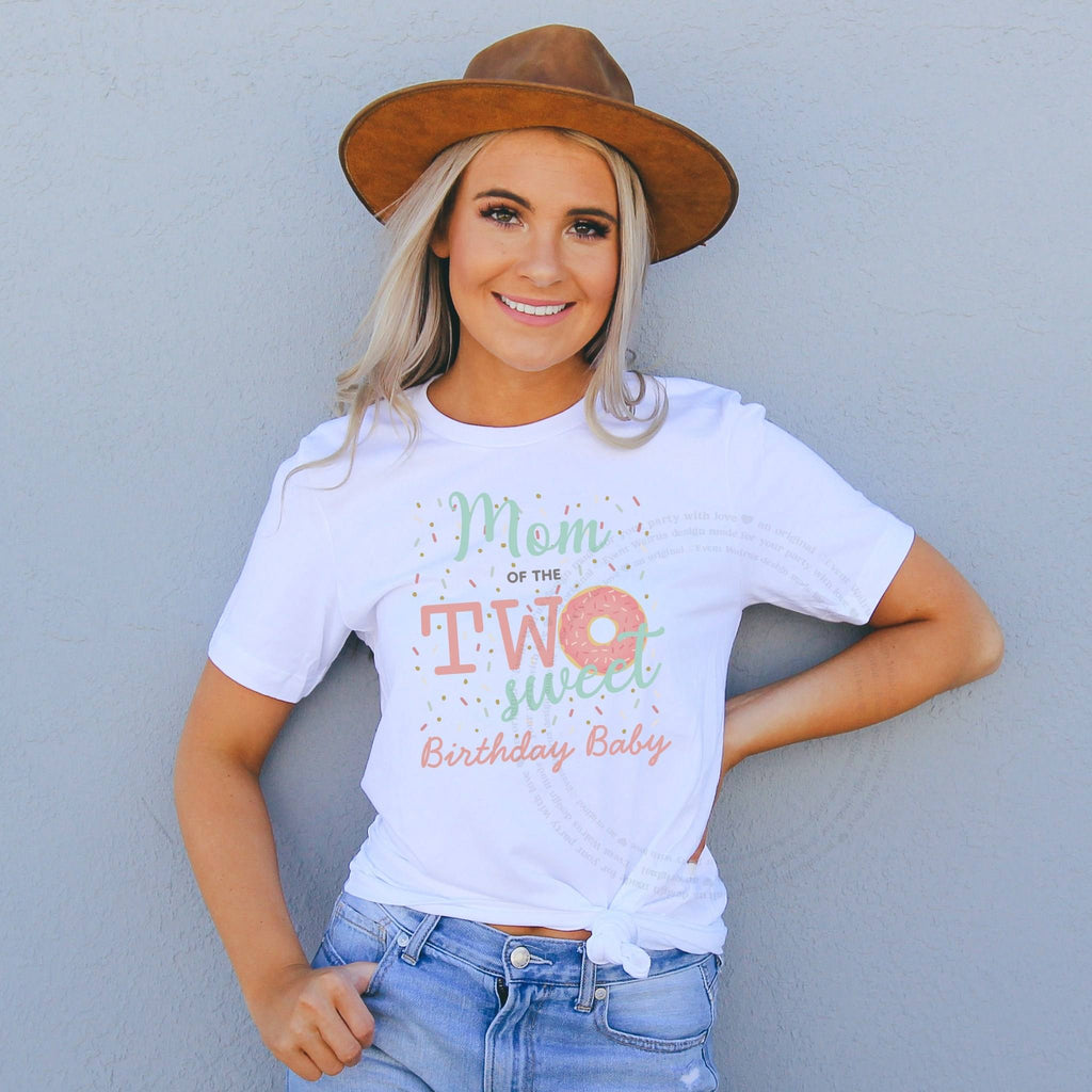 Smiling woman in a brown felt hat wearing a Mom of the Two Sweet shirt with a sprinkle donut.