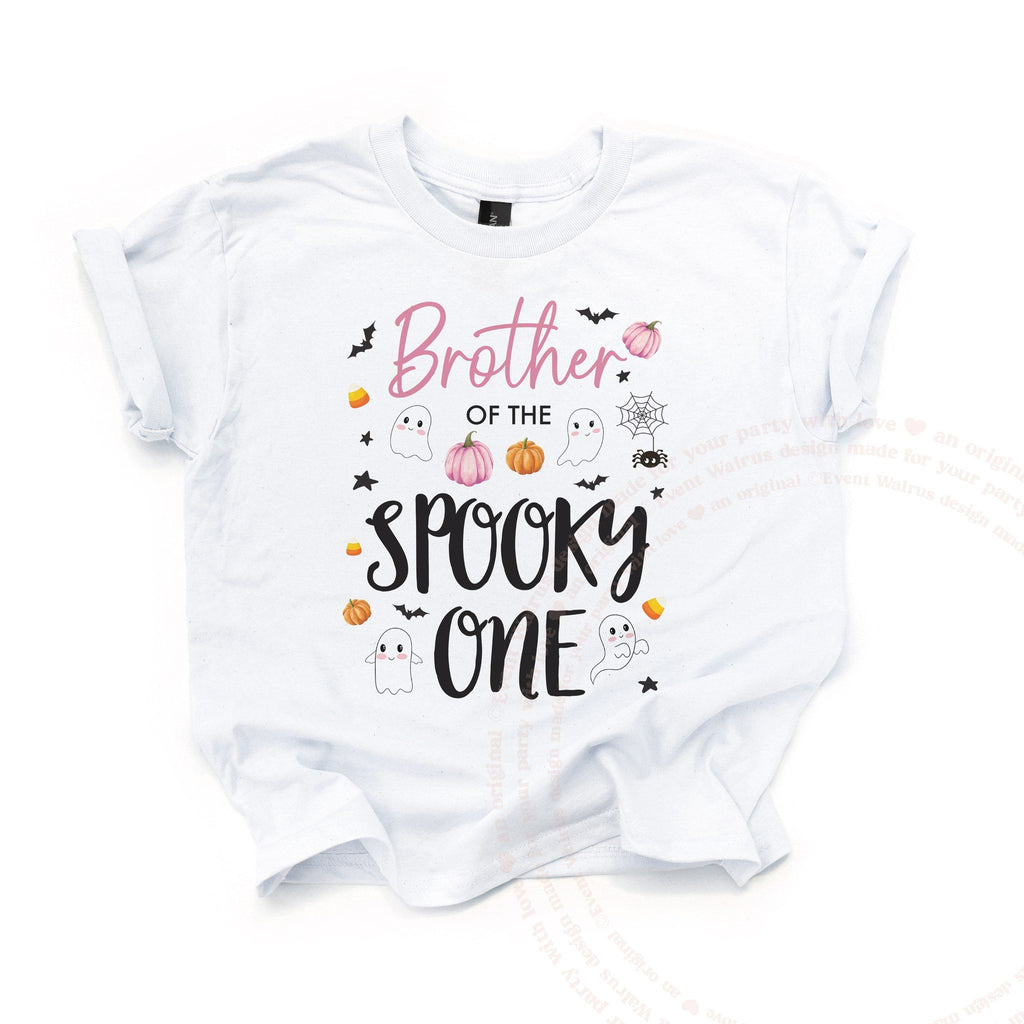 White Brother of the Spooky One kids tee laid flat, with ghosts, bats and pink pumpkins.