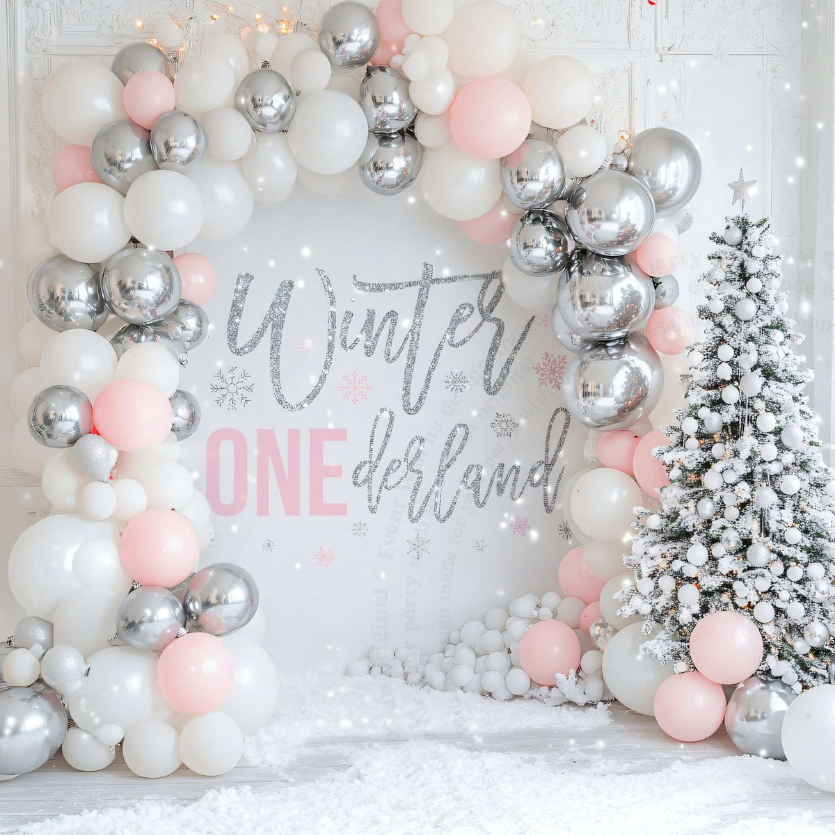 Winter onederland first birthday backdrop framed by a silver, white and pink balloon arch.