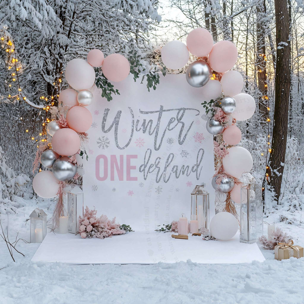 Pink glitter winter onederland backdrop in snowy woods with pink and silver balloons and lanterns.