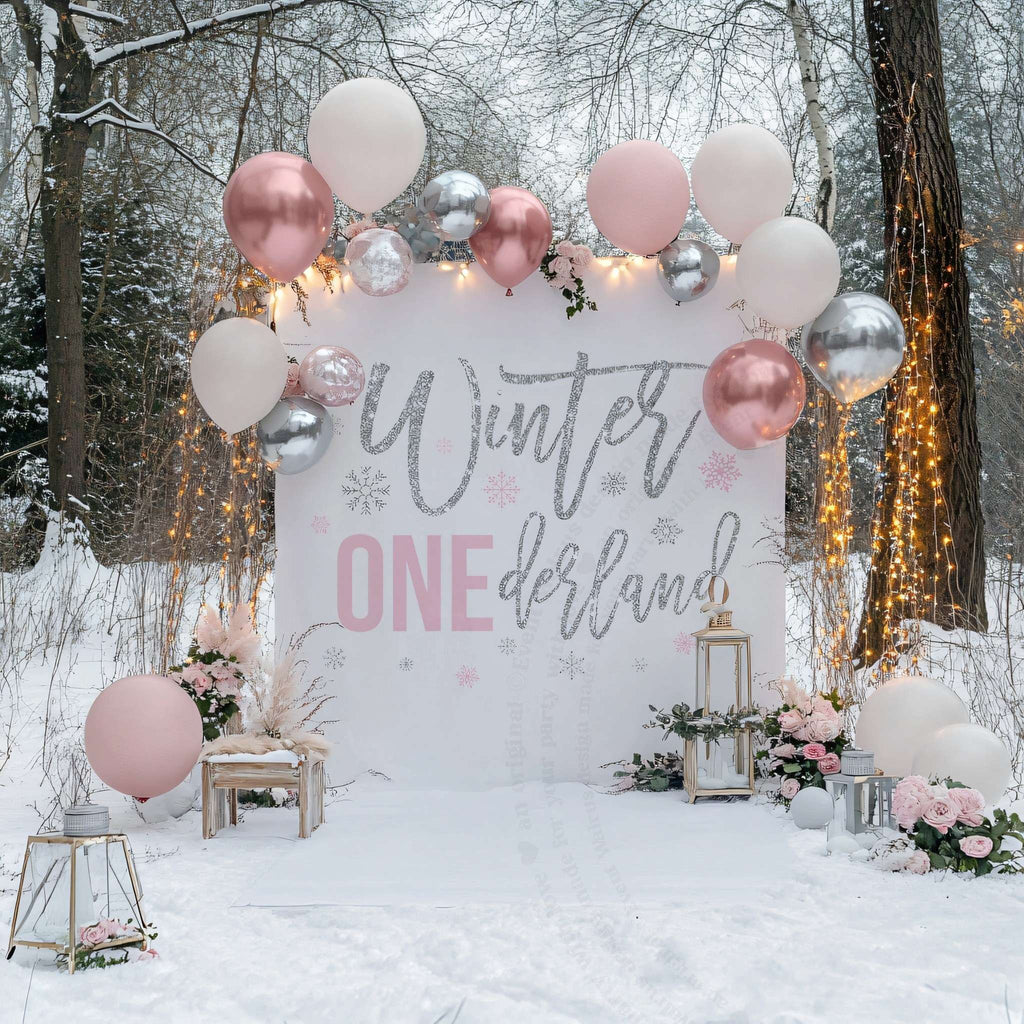 Winter onederland backdrop under string lights in the snow with blush, rose gold and silver balloons.