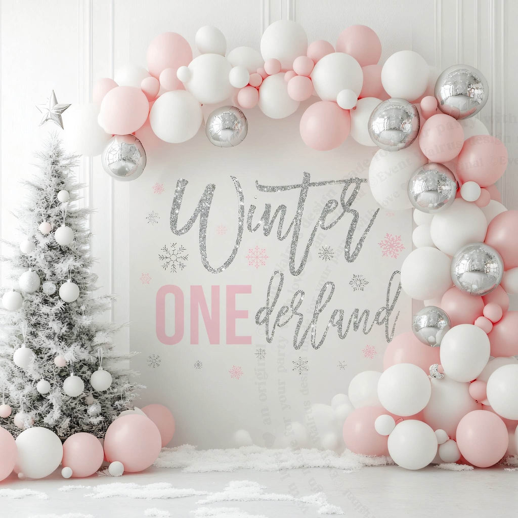 Glitter winter onederland backdrop in a white room with pink and silver balloons and a snowy tree.