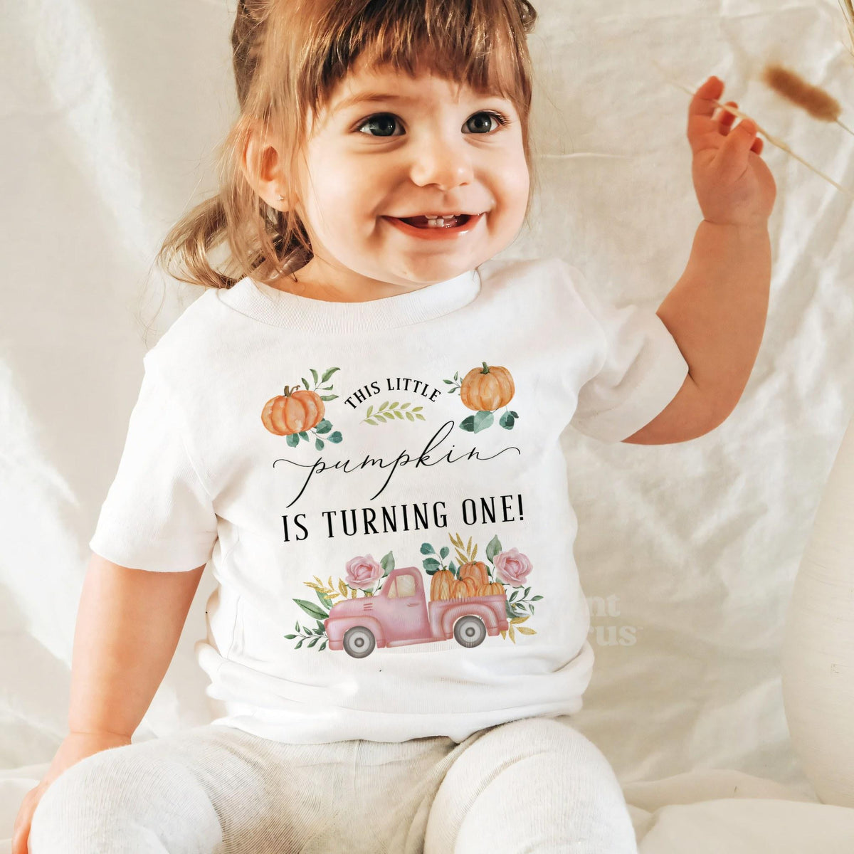 Laughing baby girl in a white pink pickup Little Pumpkin baby tee.