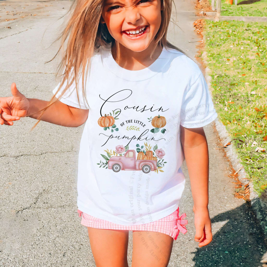 Laughing girl outdoors in a white Cousin of the Little Pumpkin kids tee.