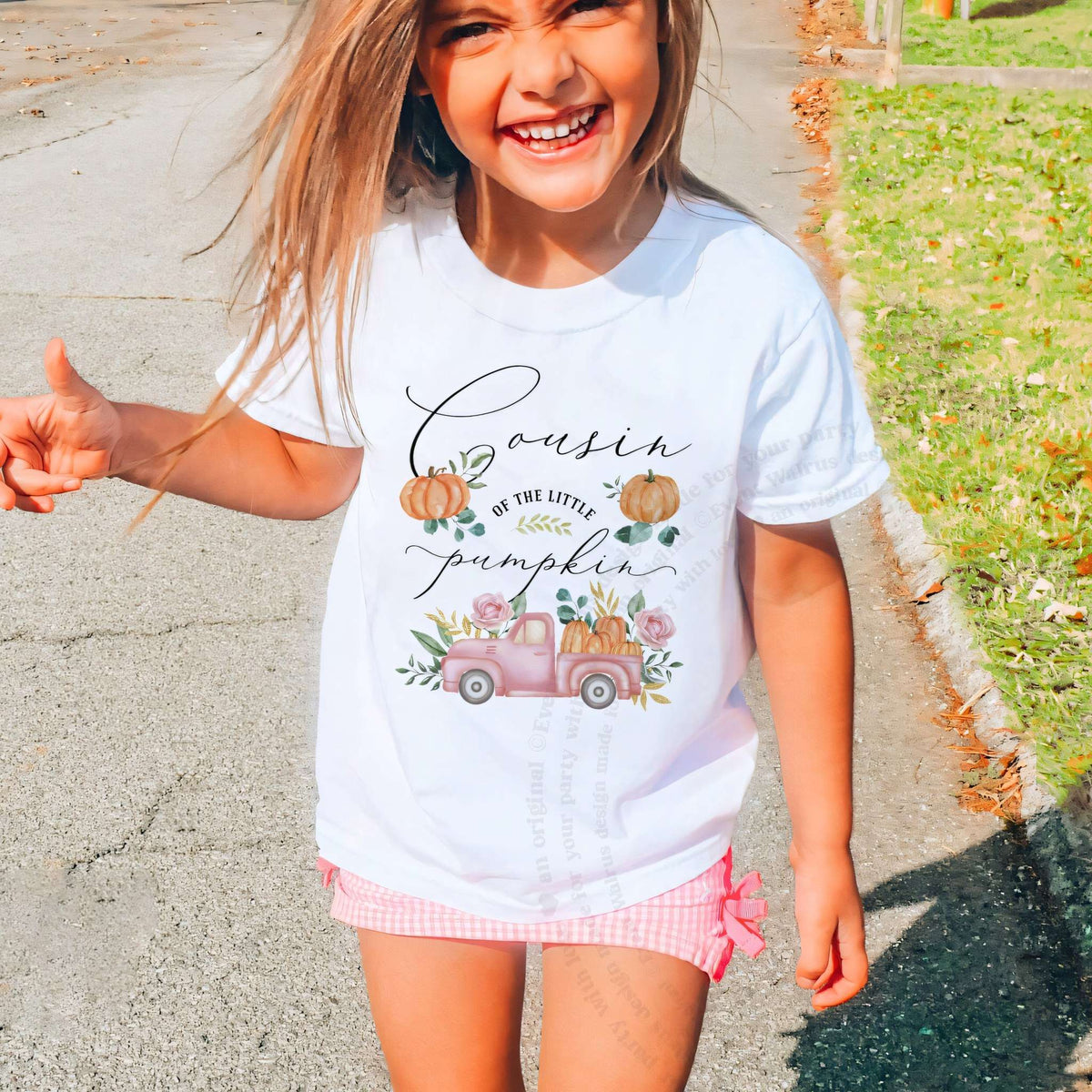 Laughing girl outdoors in a white Cousin of the Little Pumpkin kids tee.