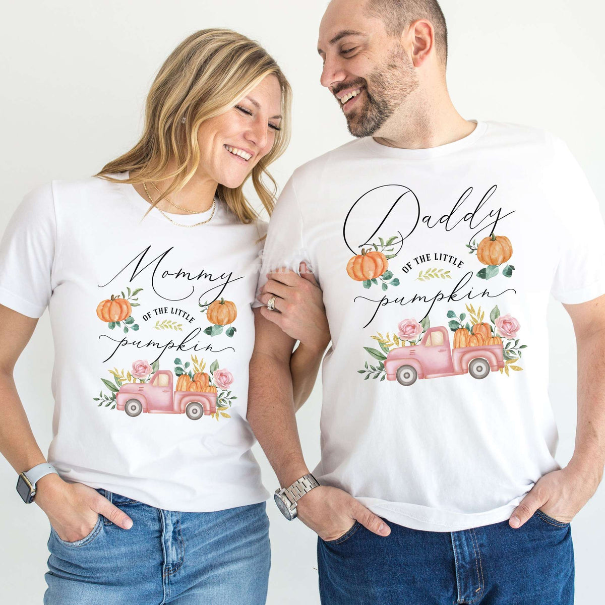 Mom and Dad laughing together in white Mommy and Daddy pink pickup Little Pumpkin shirts.