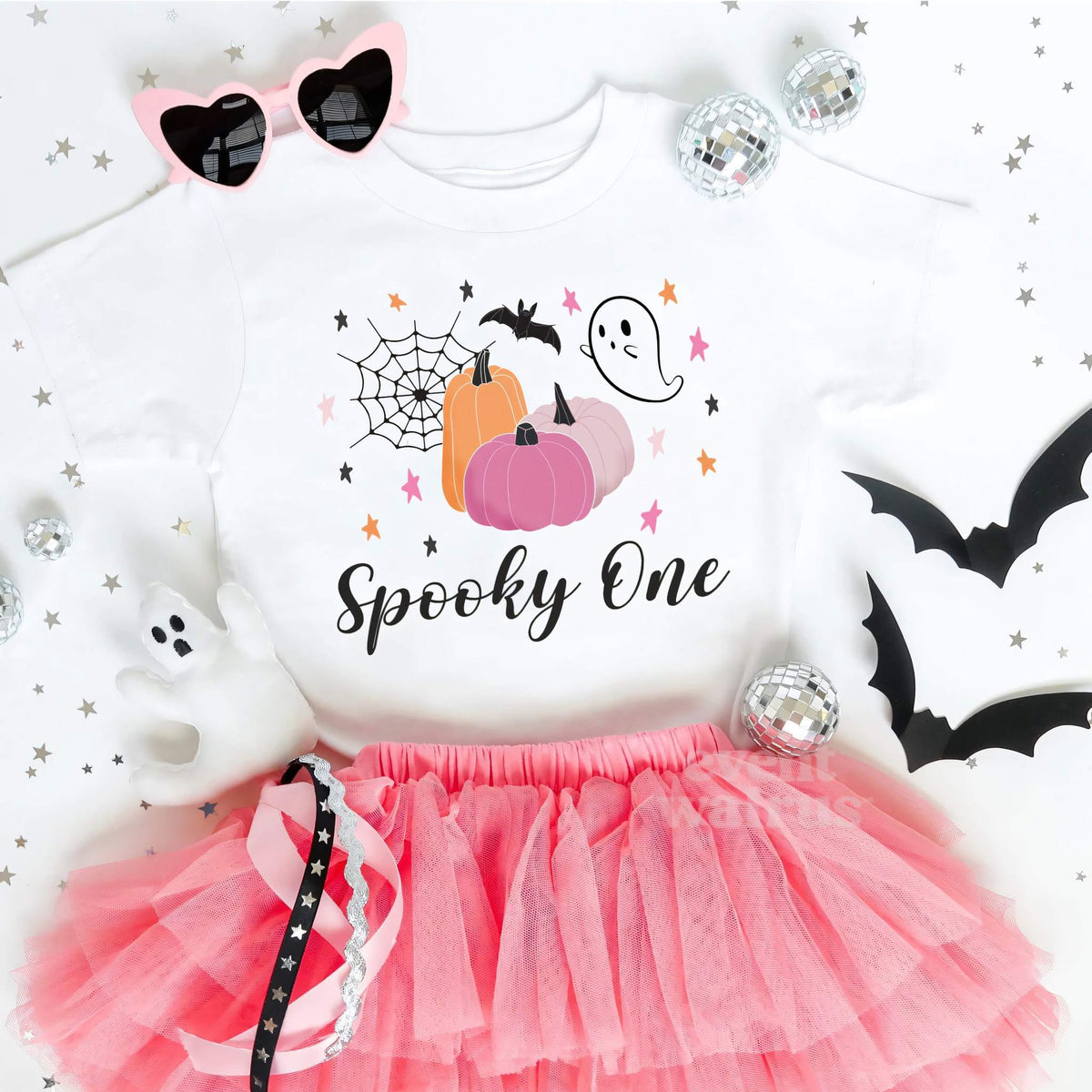 White Spooky One toddler tee laid flat with a pink tutu, heart sunglasses and paper bats.