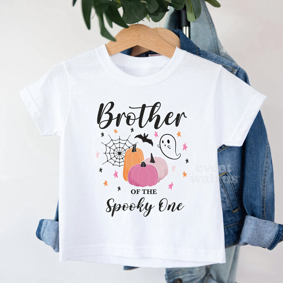 White Brother of the Spooky One toddler tee on a hanger over a denim jacket.