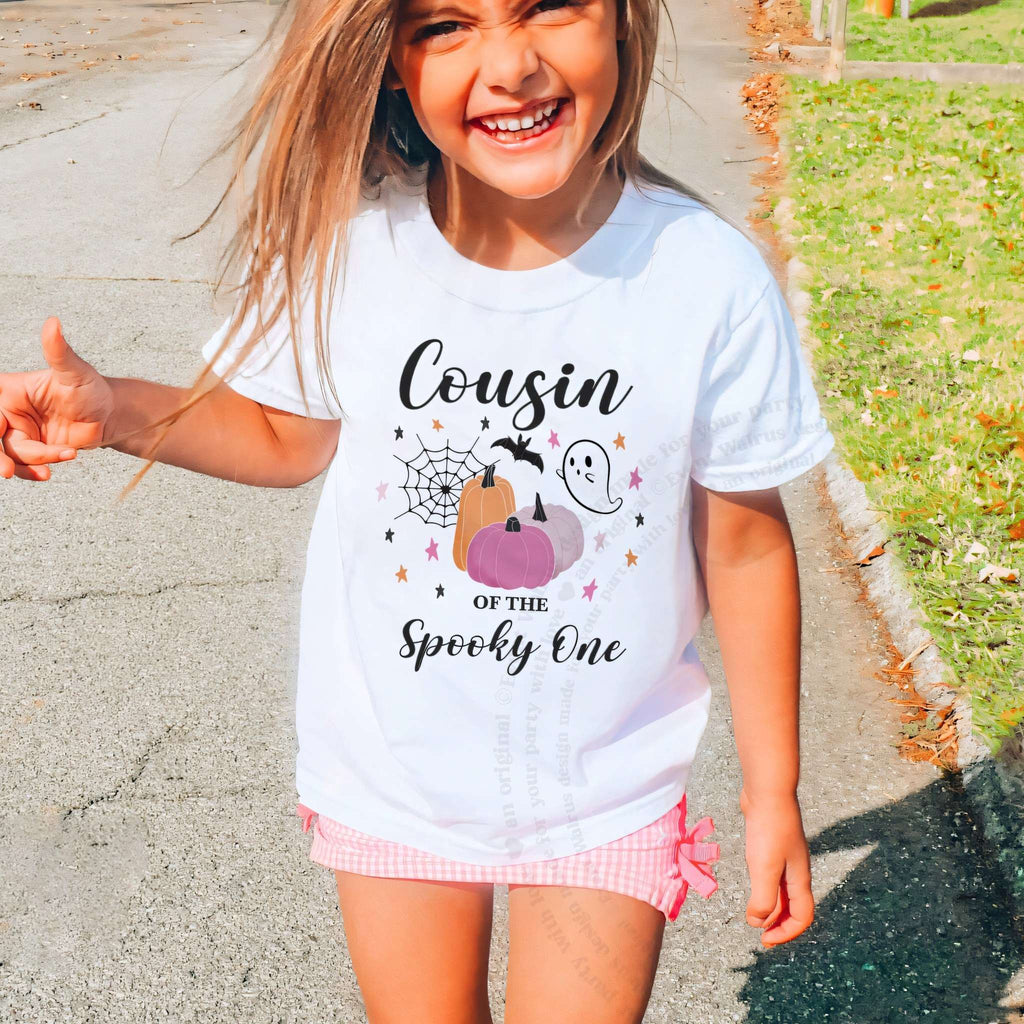 Laughing girl outdoors in a white Cousin of the Spooky One kids tee.