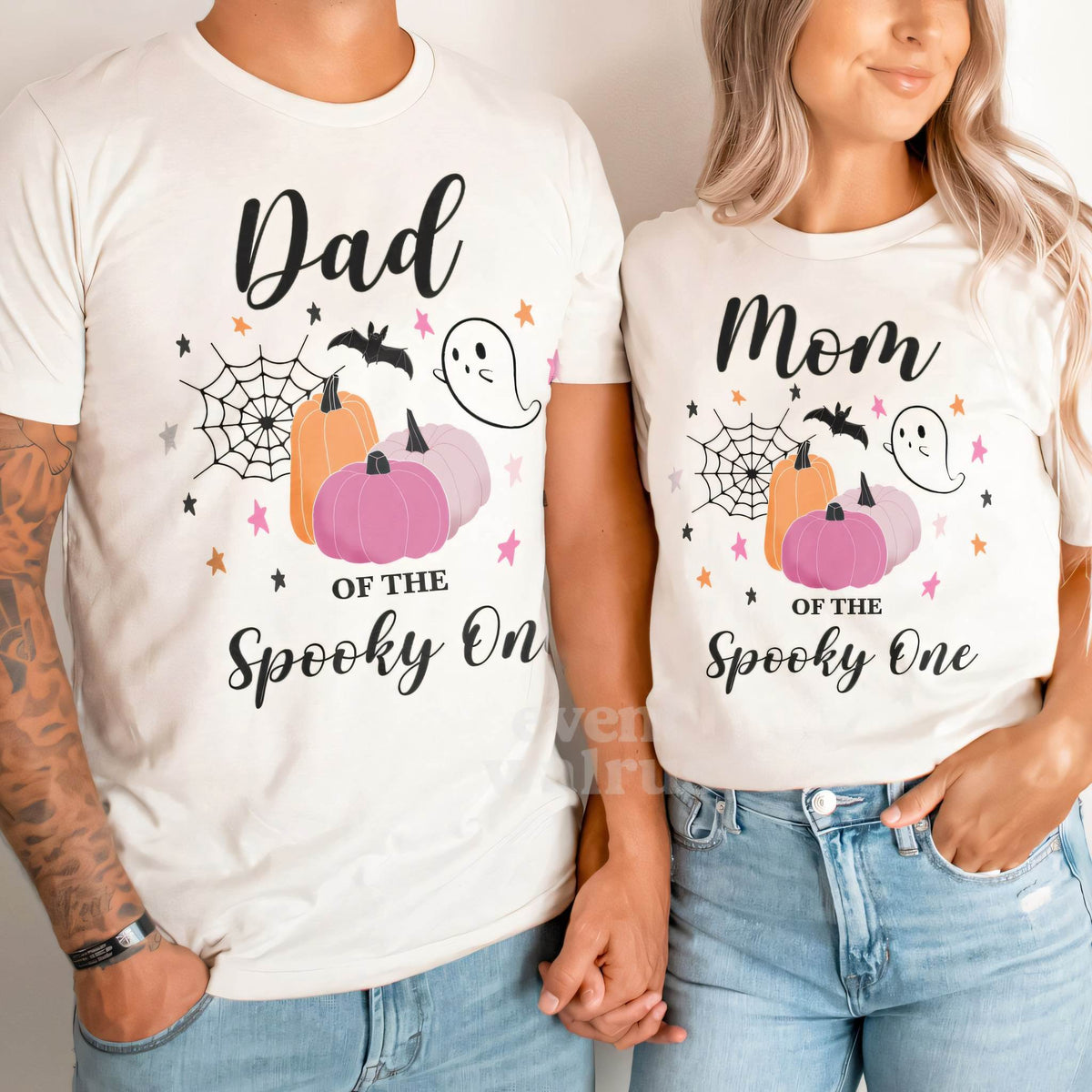 Dad and Mom holding hands in white Dad and Mom pink pumpkin Spooky One shirts.