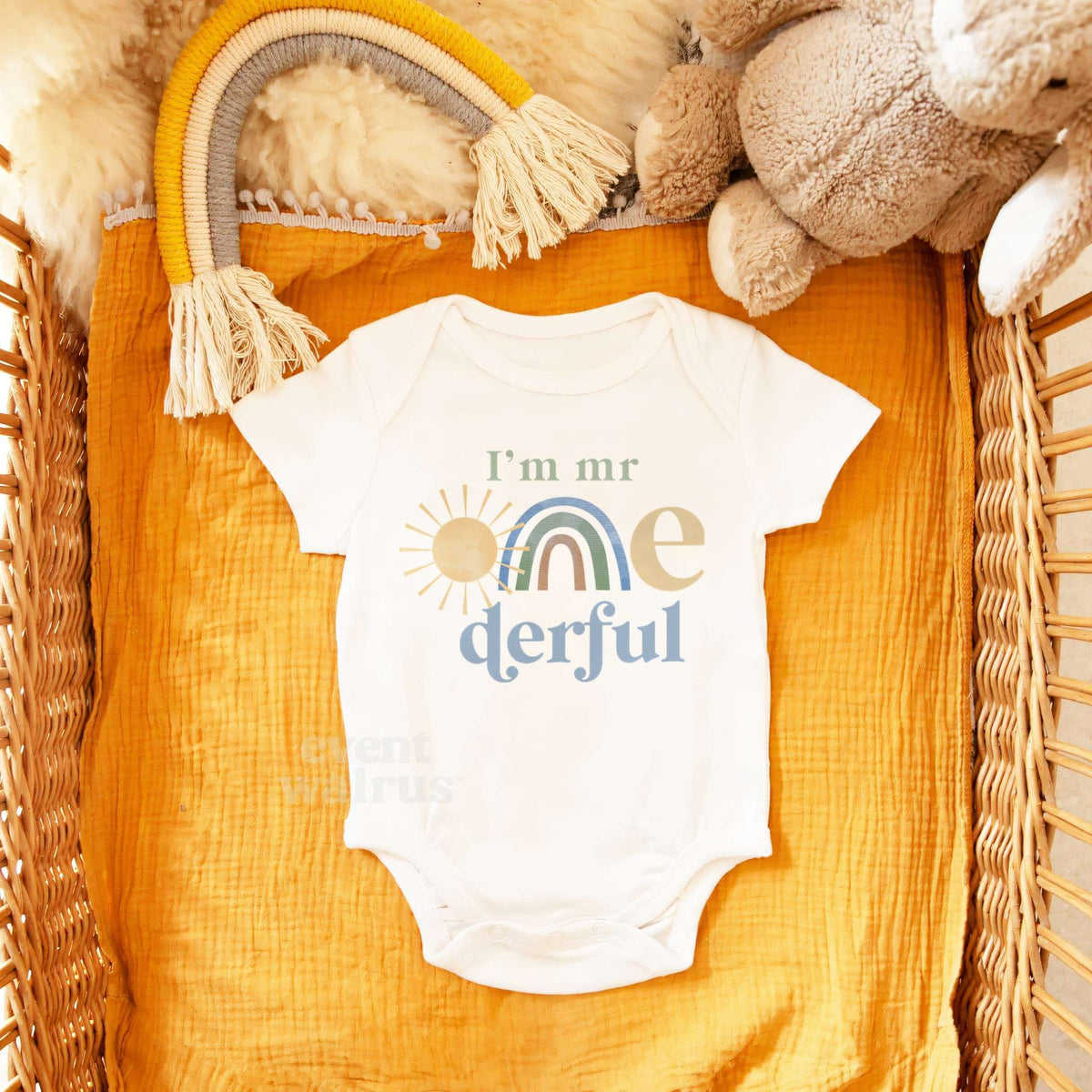 White I'm Mr Onederful bodysuit in a wicker basket with a rainbow toy and a teddy bear.