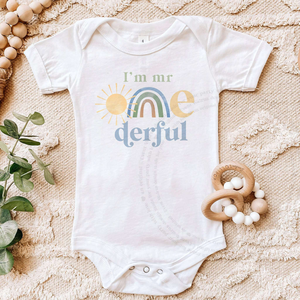 White I'm Mr Onederful bodysuit on a beige blanket with a wooden teether.