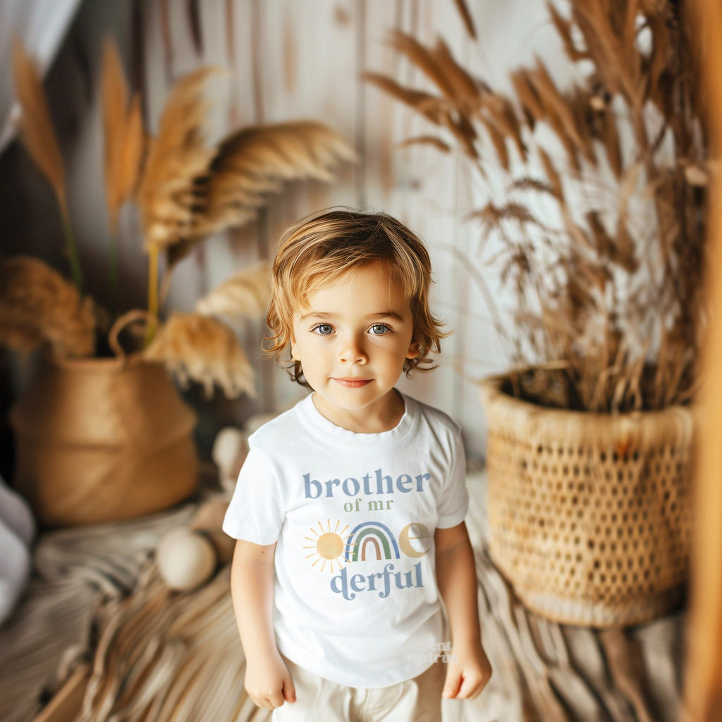 Little boy in a boho room wearing a white Brother of Mr Onederful tee.