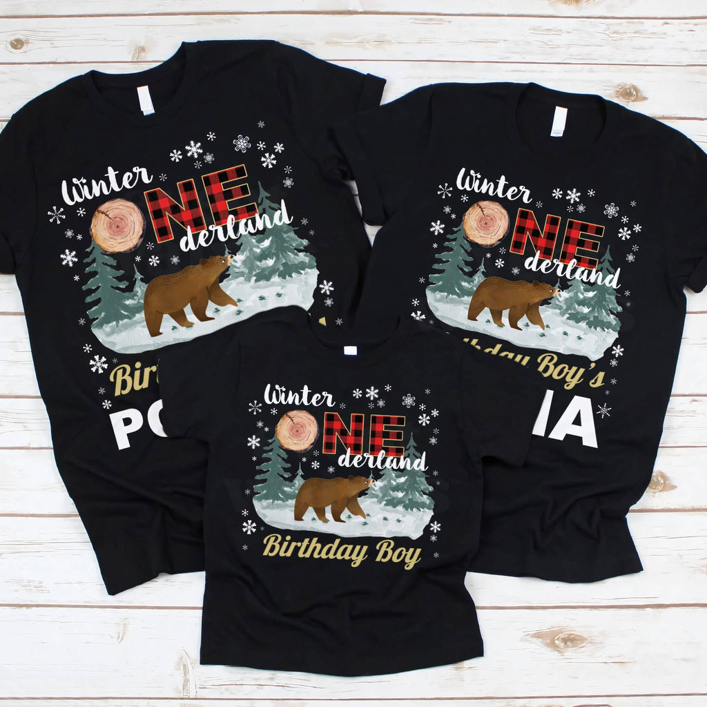 Small black Birthday Boy tee laid out between two grown-up Winter Onederland shirts.