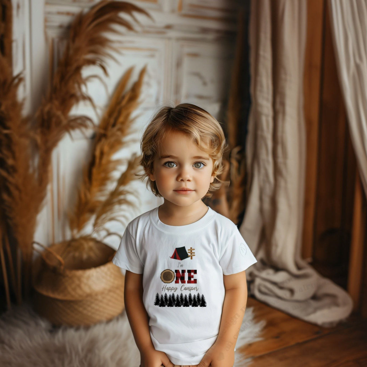 Toddler boy in a white I'm One Happy Camper tee with a red plaid ONE.
