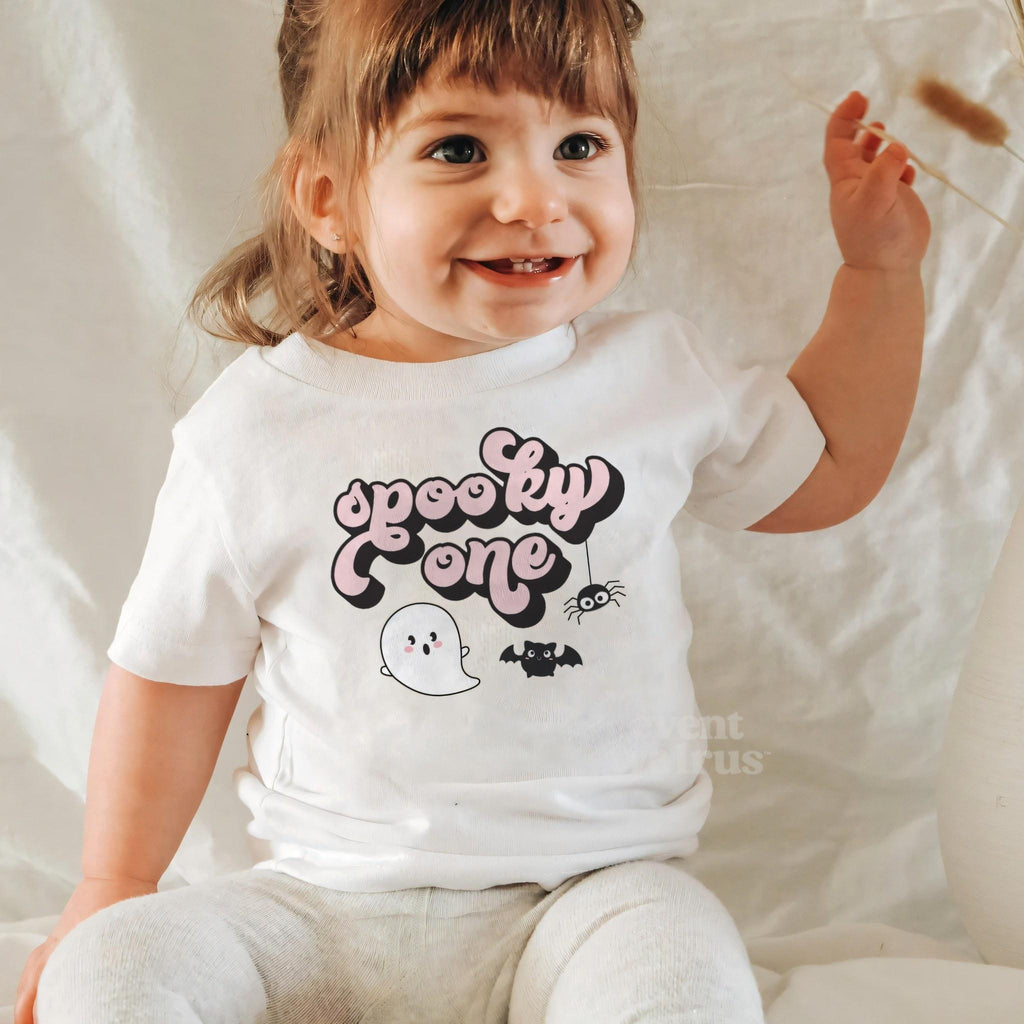 Laughing baby girl in a white Spooky One baby tee.