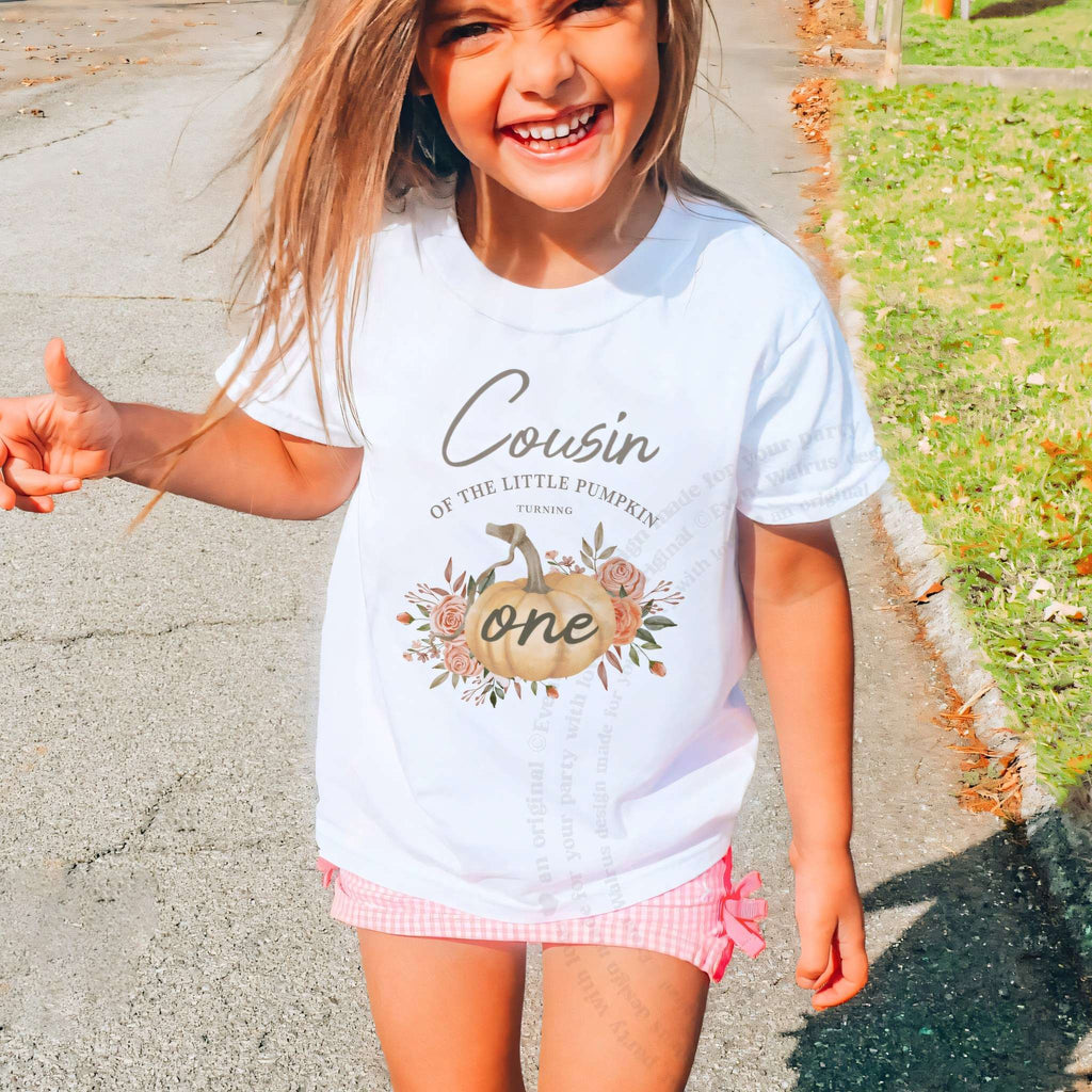 Laughing girl outdoors in a white Cousin of the Little Pumpkin kids tee.