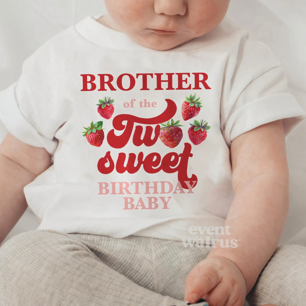 Baby sitting up in a white Brother of the Two Sweet baby tee.