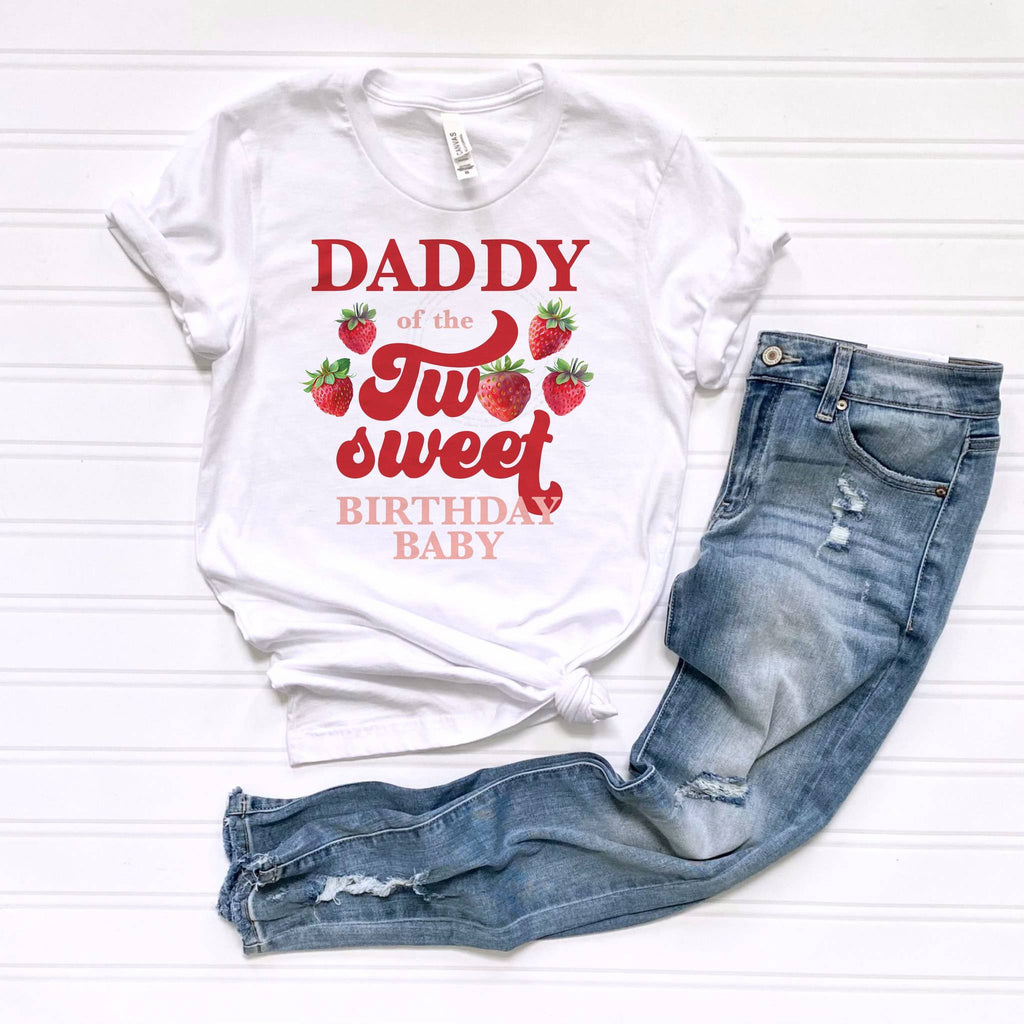 White Daddy of the Two Sweet tee laid flat beside jeans.