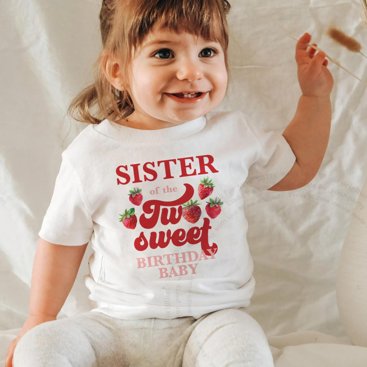 Laughing baby girl in a white Sister of the Two Sweet baby tee.