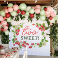 Strawberry vine two sweet backdrop on a covered patio with blush and sage balloons and strawberries.