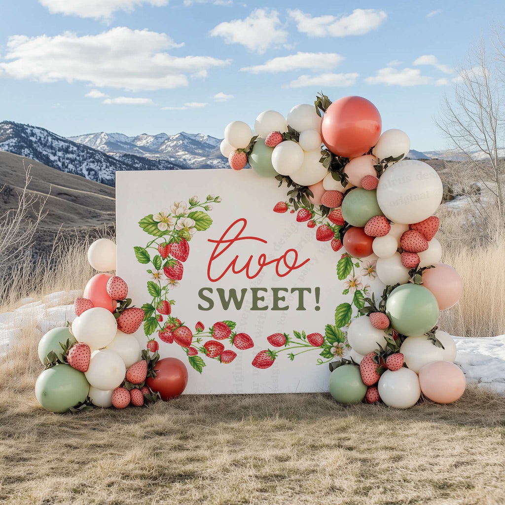 Strawberry two sweet backdrop outdoors with a mountain view and a coral and sage balloon garland.