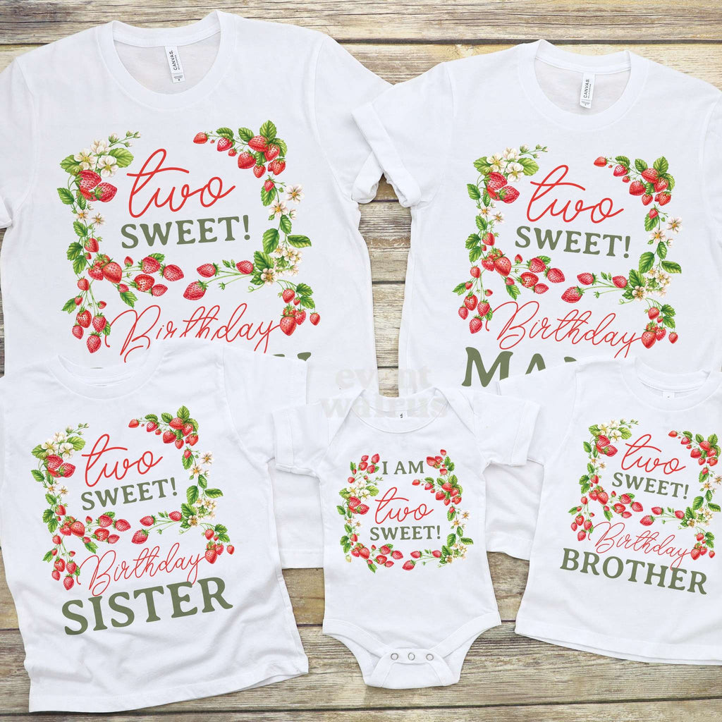Strawberry vine Two Sweet shirts for the family and a baby bodysuit laid out on wood.