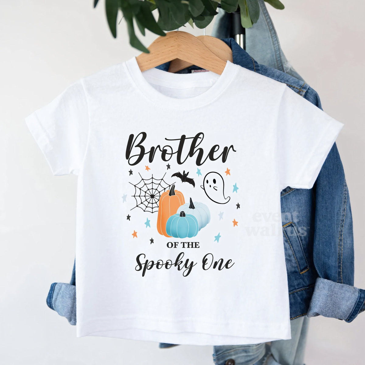 White Brother of the Spooky One toddler tee on a hanger over a denim jacket.