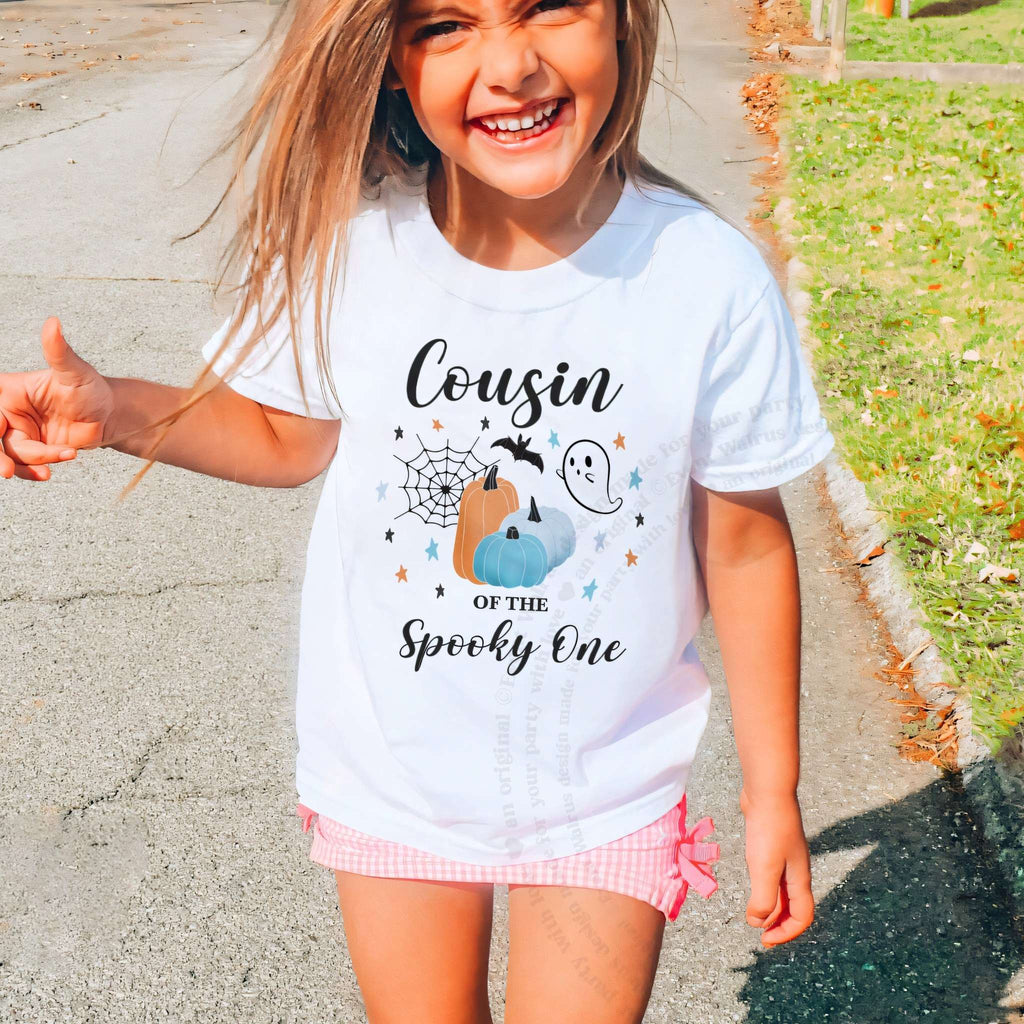 Laughing girl outdoors in a white Cousin of the Spooky One kids tee.
