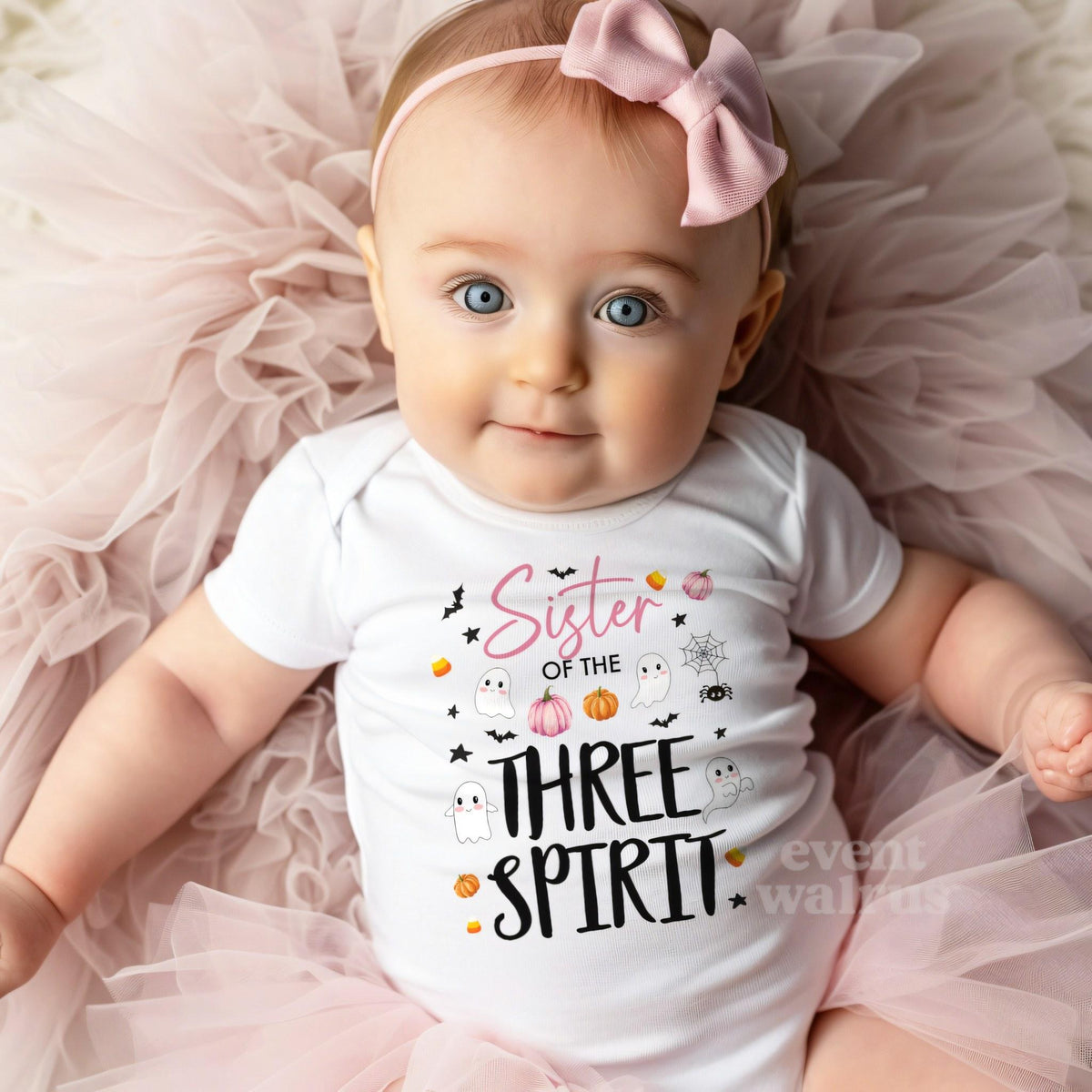 Baby girl with a pink bow on tulle in a white Sister of the Three Spirit bodysuit.