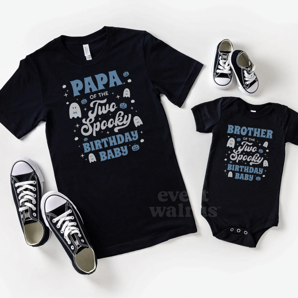 Black Two Spooky Brother bodysuit laid beside a matching Papa tee and sneakers.