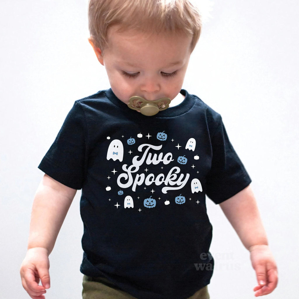 Toddler boy with a pacifier wearing a black Two Spooky ghost birthday shirt.