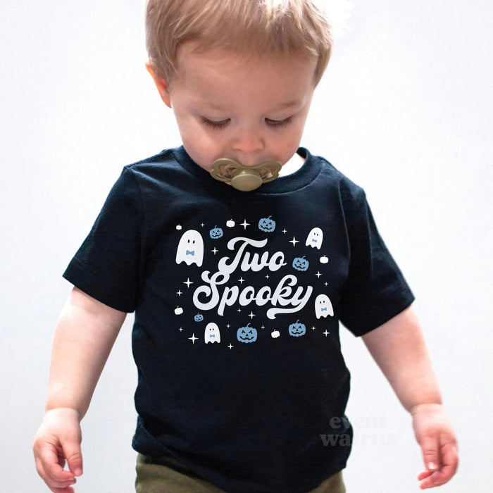 Toddler boy with a pacifier wearing a black Two Spooky ghost birthday shirt.