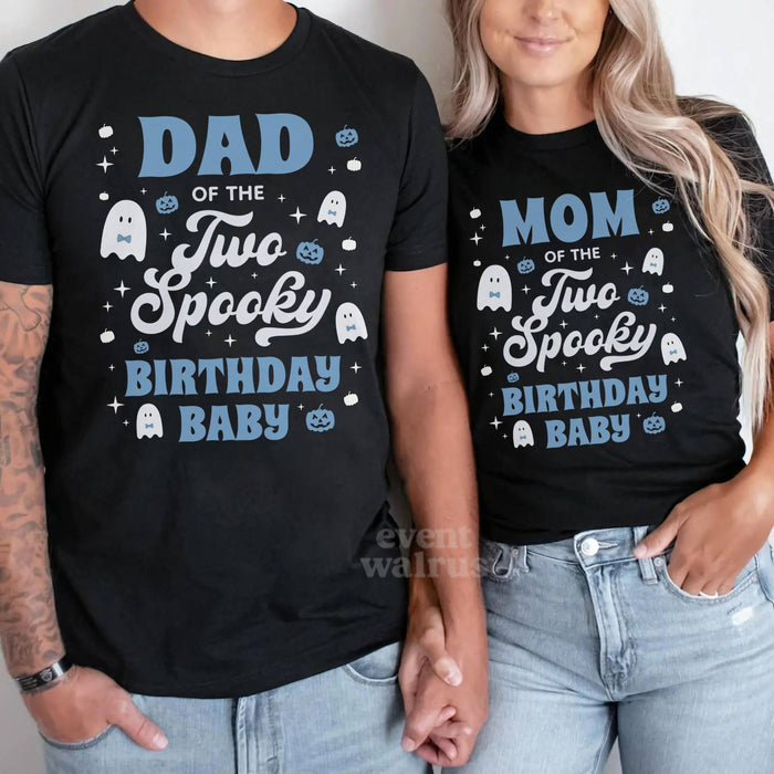 Dad and Mom in black Two Spooky Birthday Baby shirts with white ghosts and blue pumpkins.