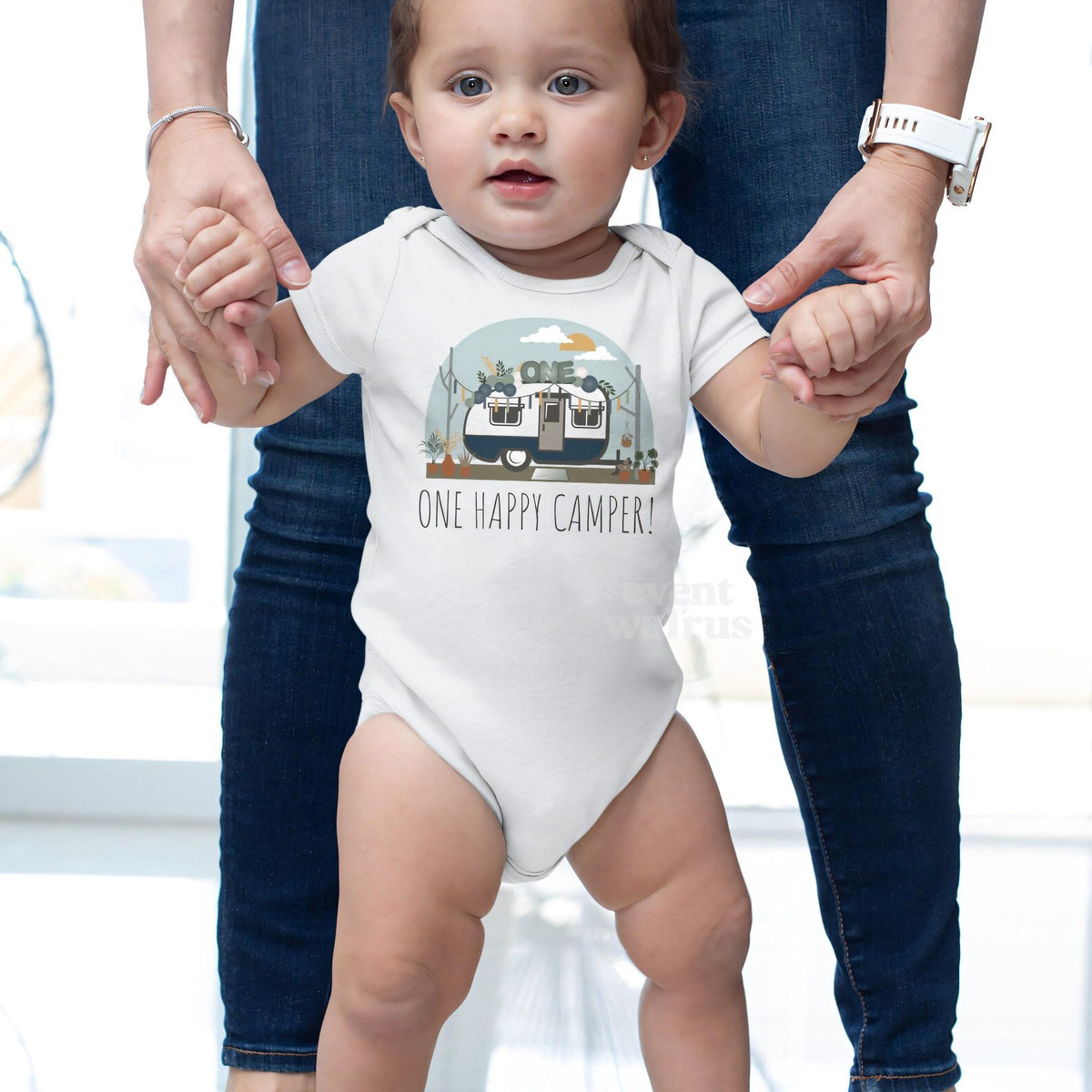 Baby taking steps while holding Mom's hands, in a white One Happy Camper bodysuit.