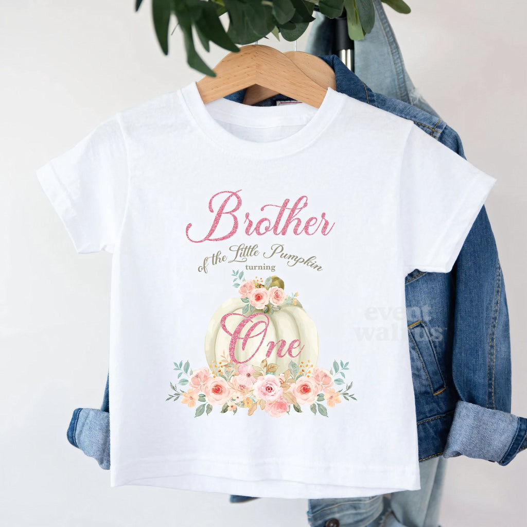 White Brother of the Little Pumpkin toddler tee on a hanger over a denim jacket.