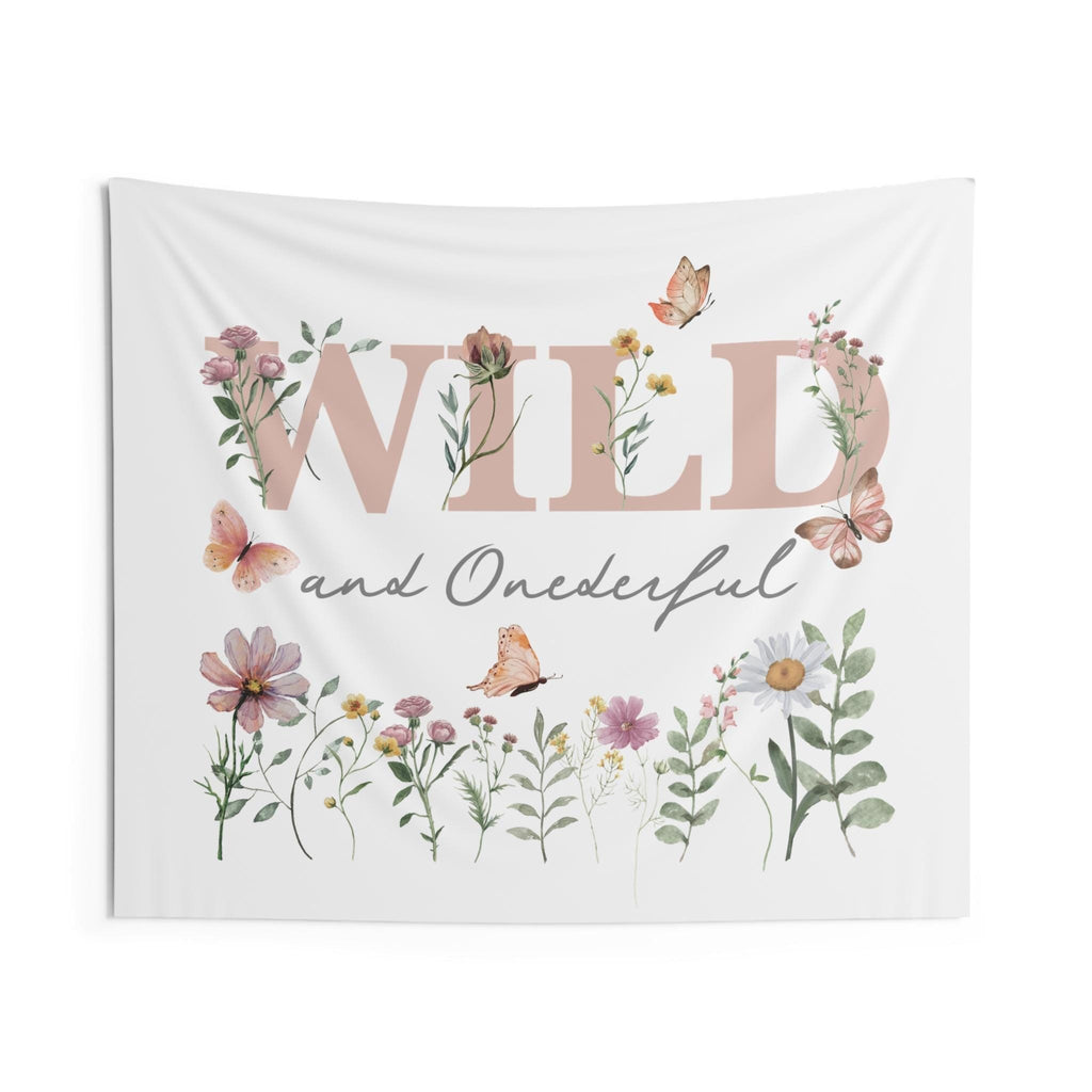 Boho first birthday backdrop reading Wild and Onederful, with peach butterflies and watercolor daisies.