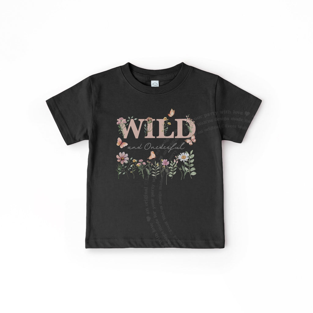 Black Wild and Onederful toddler tee laid flat, with dusty pink lettering and wildflowers.