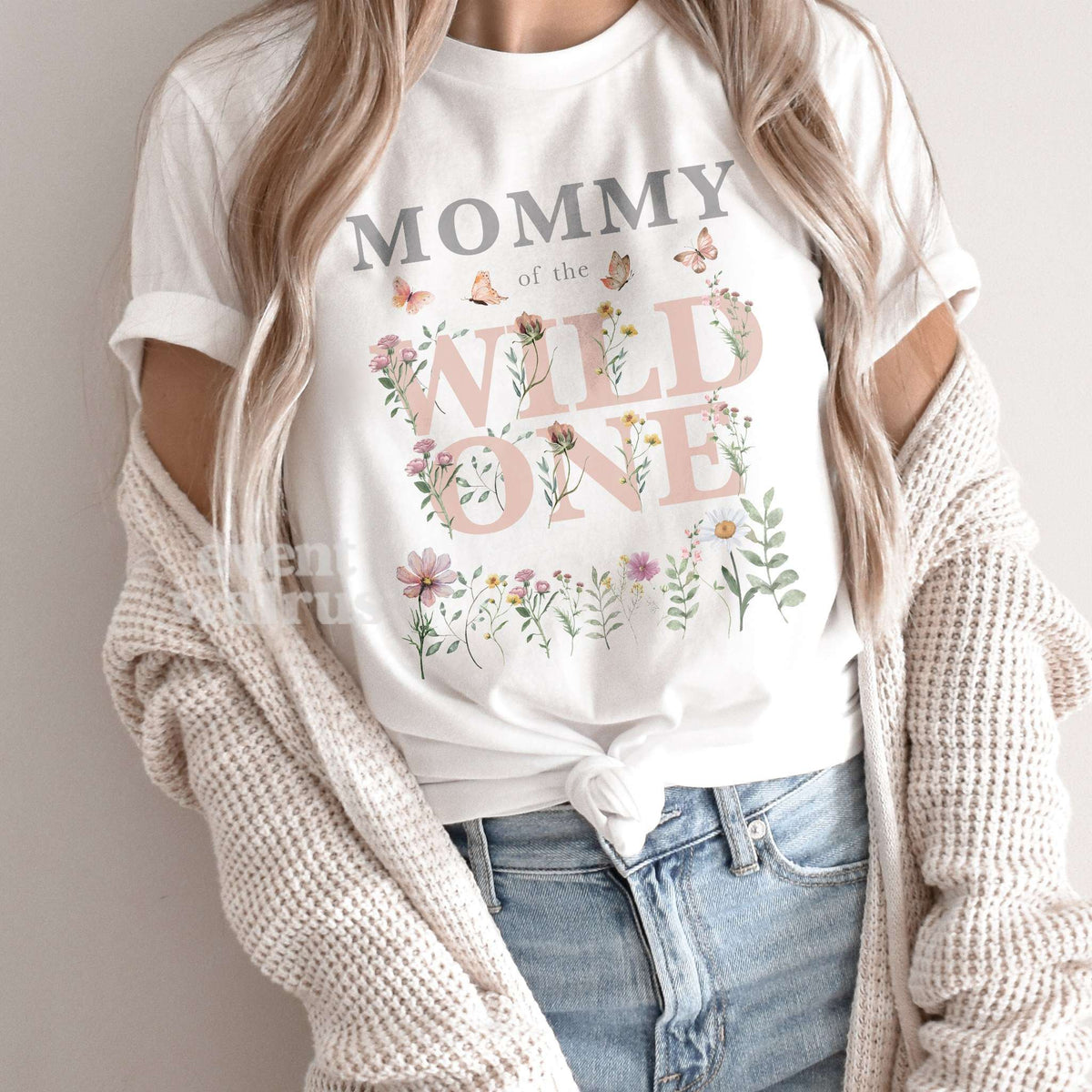 Mom wearing a white Mommy of the Wild One shirt with pink watercolor wildflowers and butterflies.
