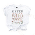 White Sister of the Wild One kids tee laid flat, with pink wildflower lettering and butterflies.
