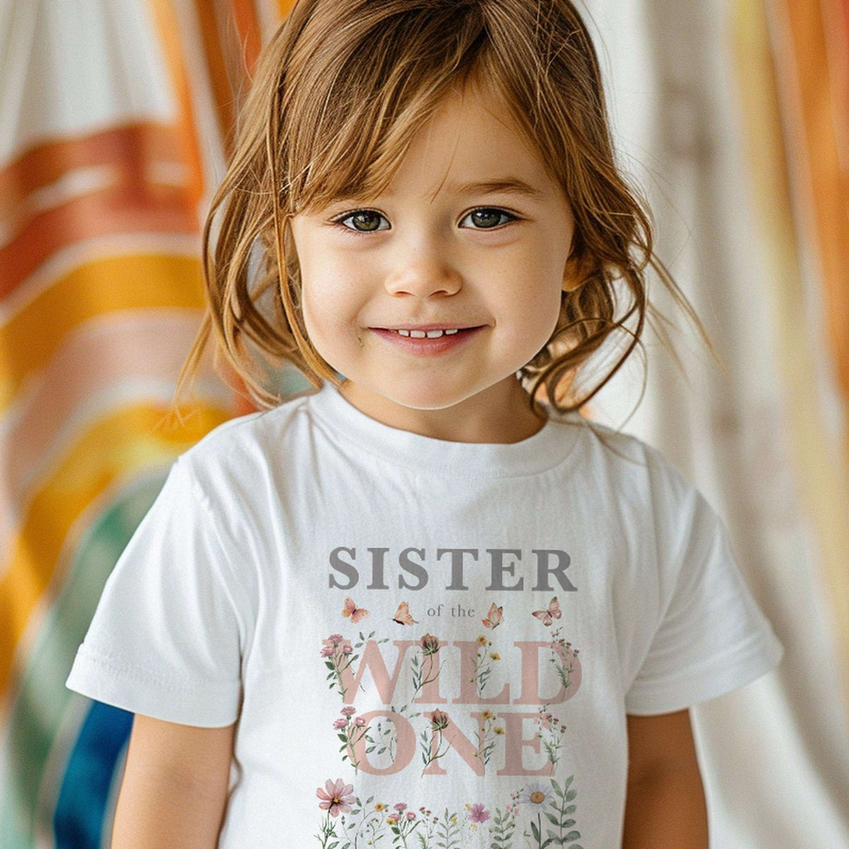 Little girl in a white Sister of the Wild One wildflower shirt.