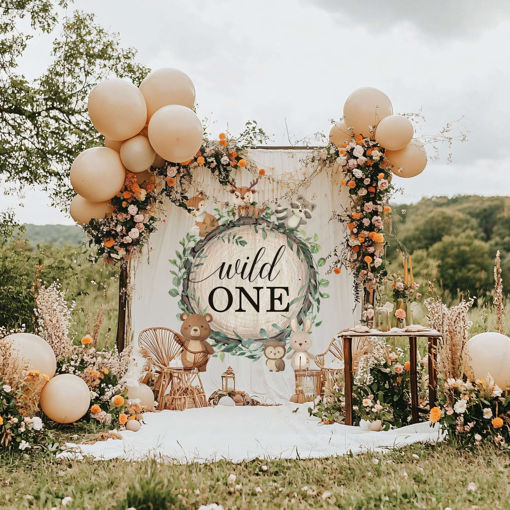 Woodland animals wild one backdrop in a meadow with peach balloons and a flower garland.